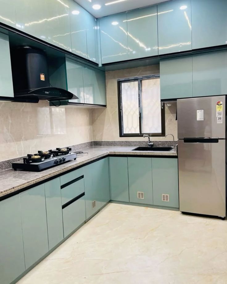 Aqua modular kitchen with overhead cabinets and integrated appliances